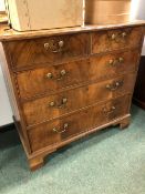 A GEORGE III WALNUT CHEST OF DRAWERS, THE TOP QUARTER VENEERED WITHIN CROSS BANDING ABOVE TWO