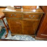 A MODERN CROSS BANDED WALNUT CABINET OF TWO DRAWERS ABOVE A CUPBOARD AND BRACKET FEET. W 70 x D 41 x