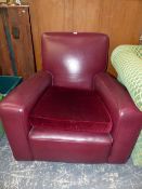 A RED LEATHER UPHOLSTERED ARMCHAIR