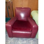 A RED LEATHER UPHOLSTERED ARMCHAIR