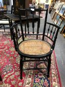 AN ARTS AND CRAFTS EBONISED ELBOW CHAIR IN MORRIS STYLE, THE THREE BARS TO THE BACK AND UNDER THE A