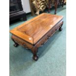 A CHINESE HARDWOOD LOW TABLE, THE RECTANGULAR TOP ABOVE AND SCROLL CARVED APRON AND LEGS ON