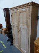 A VINTAGE PINE WARDROBE, THE TWO PANELLED DOORS ABOVE THE PLINTH FOOT. W 113 x D 41 x H 183cms.