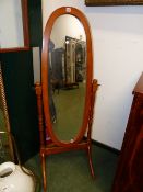 A MODERN OVAL FULL LENGTH DRESSING MIRROR ON CHEVAL STAND