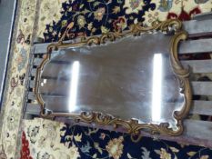 A 20th C. MIRROR IN A GILT FRAME OF S AND C SHAPED FOLIAGE SCROLLS. 117 x 63cms.