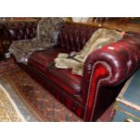 A RED LEATHER THREE SEAT CHESTERFIELD WITH BUTTONED BACK AND ARMS. W 194cms.