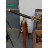 A LEATHER BOUND BRASS TELESCOPE ON TEAK STAND.