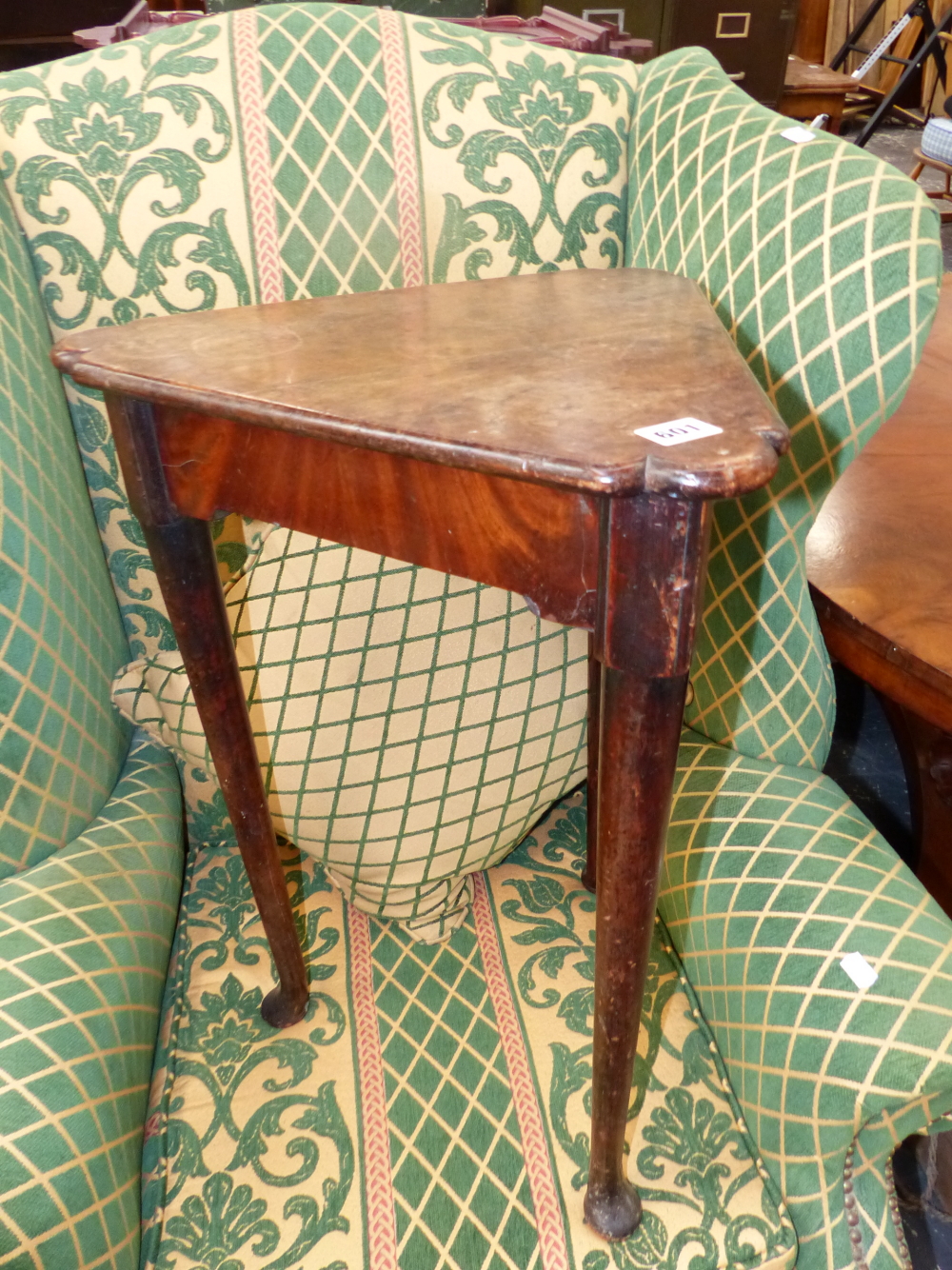 AN ANTIQUE MAHOGANY TABLE WITH THE TRIANGULAR TOP ON CYLINDRICAL LEGS TAPERING TO PAD FEET. W 44 x D