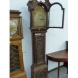 A 19th C. CARVED OAK LONG CASE CLOCK, THE ARCHED BRASS DIAL INSCRIBED WITHIN THE CHAPTER RING. H