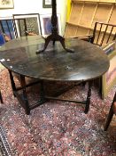 AN EARLY 18th C. OAK OVAL FLAP TOP TABLE, THE BALUSTER LEGS JOINED BY STRETCHERS ABOVE THE BUN FEET.