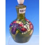 A MOORCROFT TABLE LAMP SLIP TRAILED WITH IRISES ON A GREEN GROUND. H 24cms.