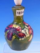 A MOORCROFT TABLE LAMP SLIP TRAILED WITH IRISES ON A GREEN GROUND. H 24cms.