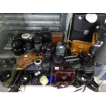 A LARGE COLLECTION OF VARIOUS BINOCULARS, CAMERAS AND LENSES, TRIPODS ETC.