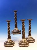 A SET OF FOUR WEDGWOOD BLACK JASPER CANDLESTICKS, SPIRALS OF HUSKS ON THE COLUMNS FLARING TO