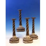 A SET OF FOUR WEDGWOOD BLACK JASPER CANDLESTICKS, SPIRALS OF HUSKS ON THE COLUMNS FLARING TO