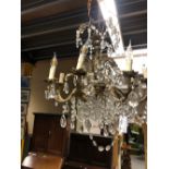 AN EIGHT LIGHT ORMOLU AND GLASS CHANDELIER, THE ARMS BELOW THE UPPER TIER CAST WITH LEAVES,