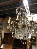 AN EIGHT LIGHT ORMOLU AND GLASS CHANDELIER, THE ARMS BELOW THE UPPER TIER CAST WITH LEAVES,