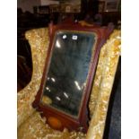 A MAHOGANY CUT WORK FRAMED MIRROR WITH A GILT FOLIATE SLIP AND SHELL INLAID OVAL. 85 x 51cms.