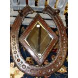 A 20th C. OAK HALL MIRROR, THE HORSESHOE SHAPE TOPPED BY TWO COAT PEGS AND CENTRED BY A DIAMOND