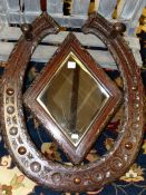 A 20th C. OAK HALL MIRROR, THE HORSESHOE SHAPE TOPPED BY TWO COAT PEGS AND CENTRED BY A DIAMOND