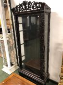 A 19th C. CHINESE HARD WOOD DISPLAY CABINET, THE GLAZED DOOR AND SIDES FLANKED BY GRAPE VINES CARVED