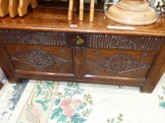 AN ANTIQUE OAK COFFER THE TWO PANELS TO THE FRONT CARVED WITH ROSETTE CENTRED DIAMONDS. W 104 x D