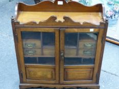 A LATE VICTORIAN OAK TABLE TOP CABINET WITH GALLERIED TOP OVER GLAZED DOORS ENCLOSING PIGEON HOLES