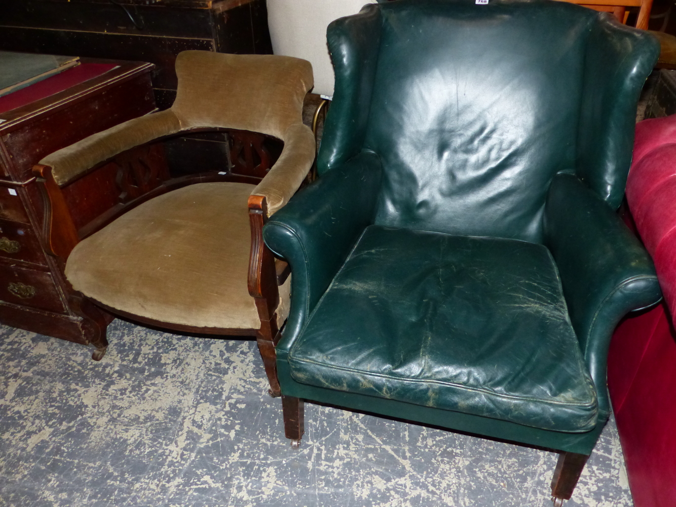 A GREEN LEATHER UPHOLSTERED WING ARM CHAIR ON SQUARE SECTION MAHOGANY LEGS WITH CASTER FEET