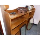 A 20th C. PINE OPEN BOOKCASE, THE SHAPED BACK OVER A LONG SHELF AND TWO BANKS OF THREE SHELVES. W