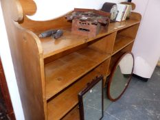 A 20th C. PINE OPEN BOOKCASE, THE SHAPED BACK OVER A LONG SHELF AND TWO BANKS OF THREE SHELVES. W