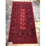 A MACHINE MADE RUG OF BOKHARA DESIGN, 197 x 90cms