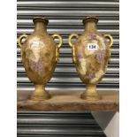 A PAIR OF AMPHORA BALUSTER VASES WITH TWO GILT HANDLES AND DECORATED WITH GRAPES.