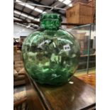 A LARGE GREEN GLASS JAR.