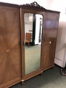 A SATIN WOOD AND INLAID TRIPLE WARDROBE WITH CENTRAL MIRRORED DOOR ENCLOSING SHELVES, W 187 X H 200.