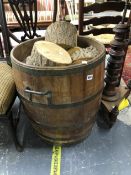 A COOPERED LOG BARREL WITH LOGS.