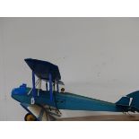 A SCALE MODEL BIPLANE ONCE POWERED BY A LIVE FUEL SINGLE PROP ENGINE.