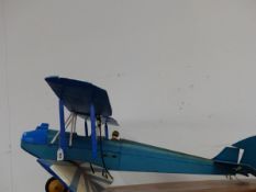 A SCALE MODEL BIPLANE ONCE POWERED BY A LIVE FUEL SINGLE PROP ENGINE.