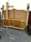 AN ANTIQUE GILDED AND CANED FRENCH DOUBLE BED. W 158 X 135cms.