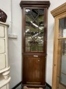 AN ANTIQUE MAHOGANY AND GLAZED FLOOR STANDING CORNER CABINET.