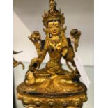 AN EASTERN GILDED BRONZE SEATED DEITY.