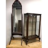 A CHEVAL MIRROR AND A SMALL DISPLAY CABINET.