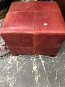 A RED LEATHER UPHOLSTERED STOOL.