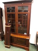 AN EDWARDIAN MAHOGANY GLAZED BOOKCASE ON CABINET BASE. W 125 X D 45 X H 168cms.