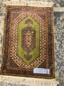 A FINELY WOVEN SILK SMALL RUG 74 x 33cms