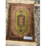 A FINELY WOVEN SILK SMALL RUG 74 x 33cms