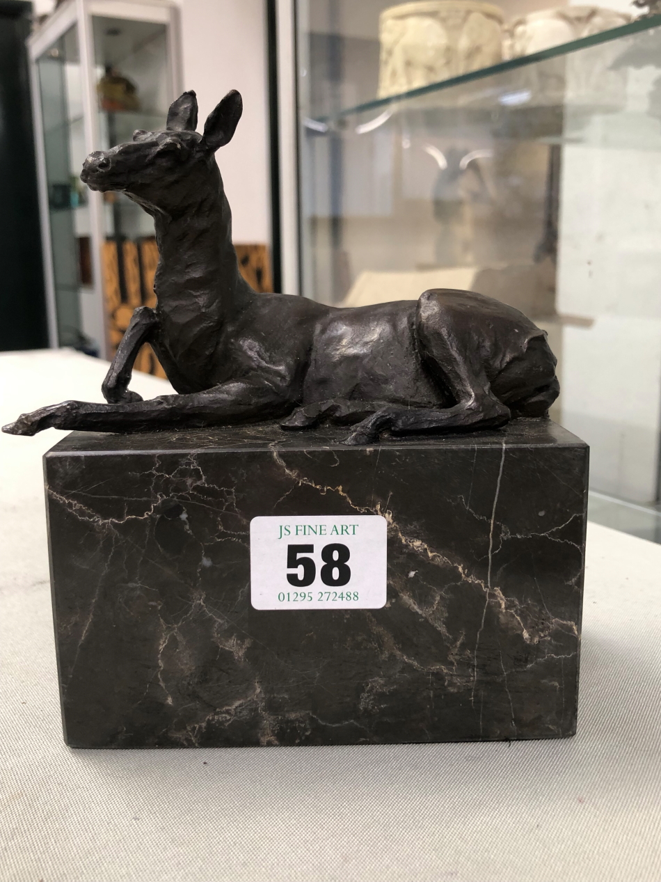 A BRONZE FIGURE OF A SEATED DEER ON A MARBLE PLINTH SIGNED L. CARVIN.