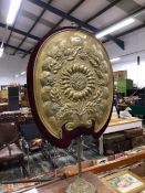 AN ANTIQUE BRASS FIRE SCREEN ON ADJUSTABLE POLE STAND.