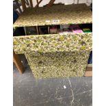 A FLORAL CLOTH COVERED FOUR DRAWER CHEST CONTAINING LIGHT BULBS, WEBBING AND LINENS TOGETHER WITH