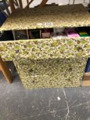 A FLORAL CLOTH COVERED FOUR DRAWER CHEST CONTAINING LIGHT BULBS, WEBBING AND LINENS TOGETHER WITH