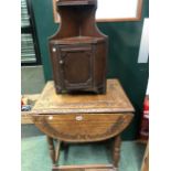 A SMALL OAK CARVED OCCASIONAL TABLE AND A CORNER CABINET.